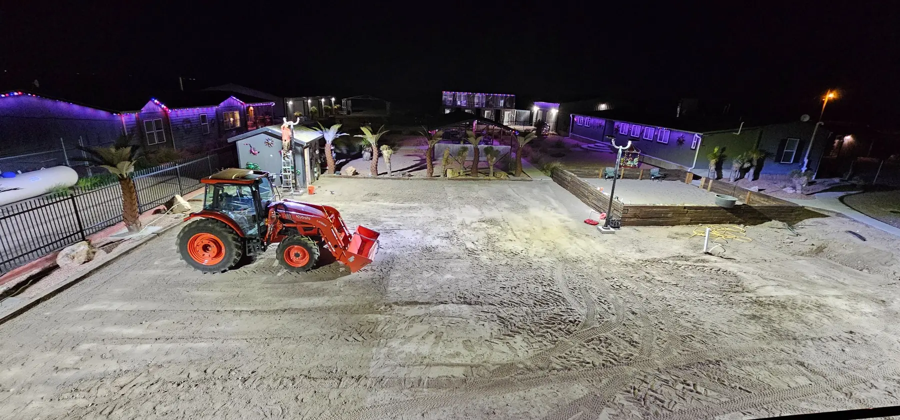 Perimeter lighting illuminating a large property and active work area at night
